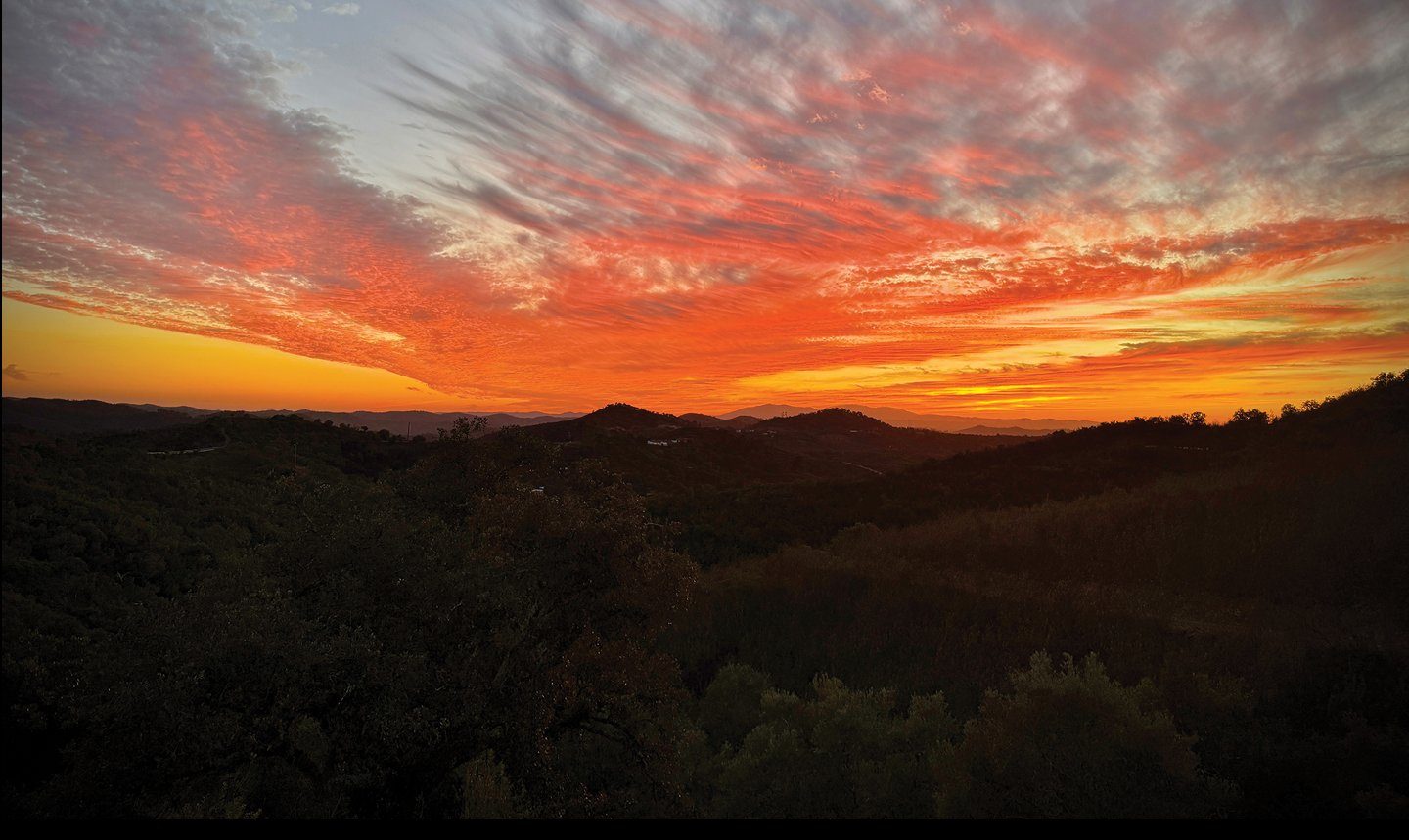 A fiery sunset over the hills of the Serra do Caldeirão